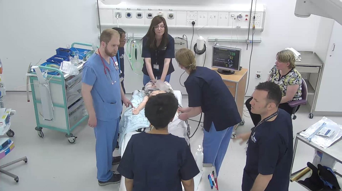 Faculty and delegates running a simulated paediatric resuscitation around a child manikin