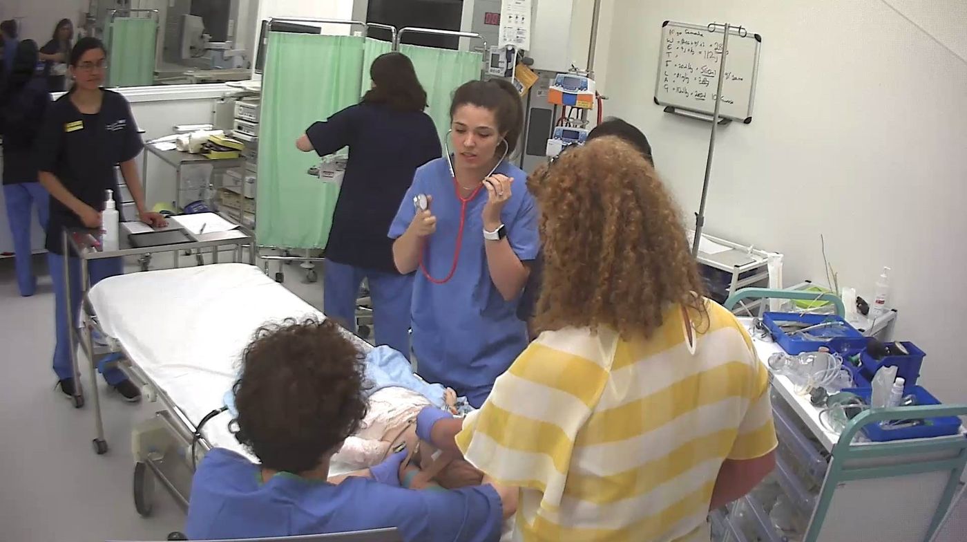 Team members examining a child manikin on a trolley during a simulation